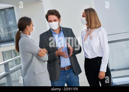 Team of businesspeople working in protective masks Stock Photo