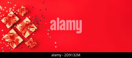 Several gift boxes with bows on a red background. Stock Photo