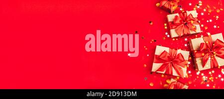Several gift boxes with bows on a red background. Stock Photo