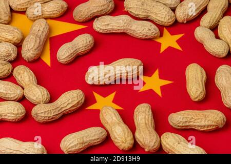 Closeup of peanuts in shell on flag of China. Concept of peanut farming, trade, tariffs and market price Stock Photo