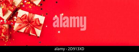 Several gift boxes with bows on a red background. Stock Photo