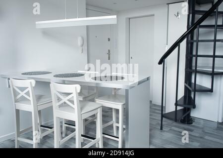 The minimalistic interior of a small two-story apartment. Stock Photo