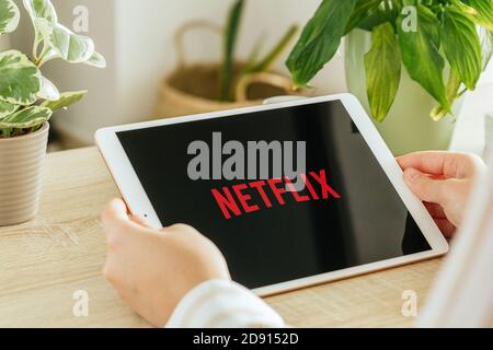 VALENCIA, SPAIN - OCTOBER, 2020: Netflix app on a tablet screen. Young Girl is watching On demand TV shows, Documentary, Series and Movies via tablet