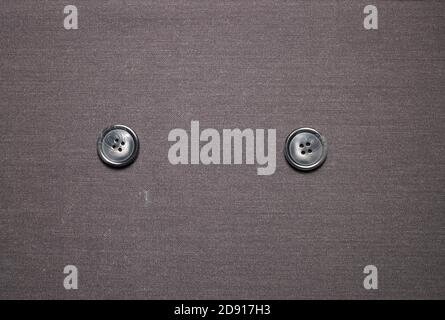 buttons resting on a gray material fabric Stock Photo