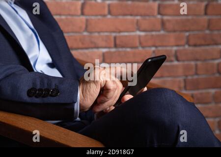 Closeup shot of a businessman working on his smartphone Stock Photo