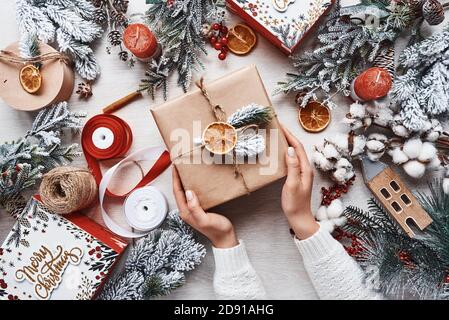 Girl making gift box. Top view of christmas festive frame with new year decorations Stock Photo