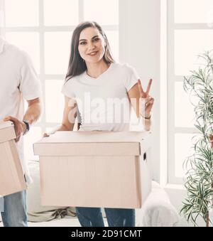 young family with cardboard boxes standing in a new apartment. Stock Photo
