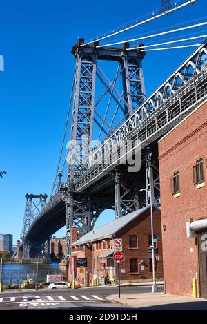 Looking up at the Williamsburg Bridge as it crosses the East River to the Lower East Side of Manhattan. Stock Photo