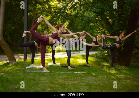 Women doing stretching exercise, group yoga Stock Photo