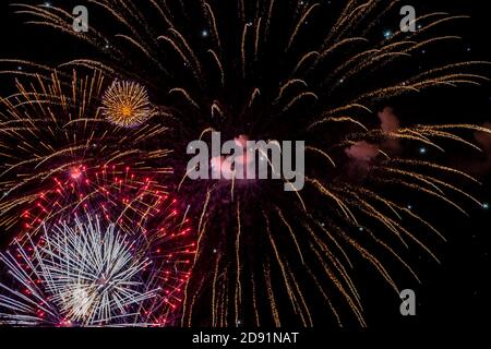 Looking up at fireworks exploding against a night sky Stock Photo