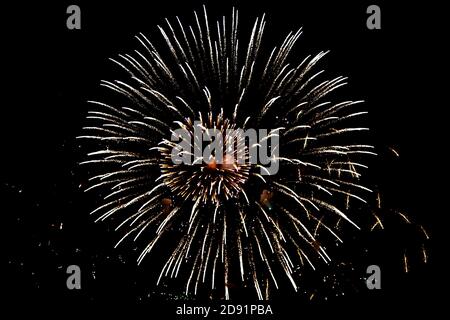 Looking up at fireworks exploding against a night sky Stock Photo