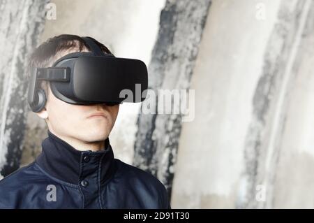 portrait of a serious young man with VR glasses, security guard and police inspector using future virtual reality technologies protect the law Stock Photo