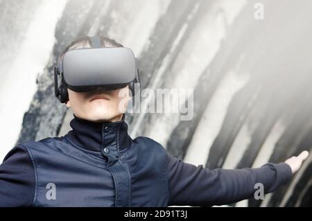 portrait of a young man enjoys virtual reality glasses during simulation training  with modern imaging future technologies Stock Photo