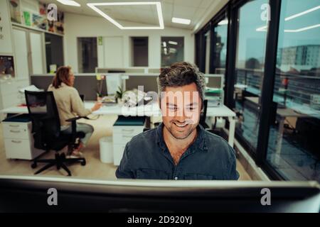 Caucasian businessman typing on desktop computer finishing business report for boss Stock Photo