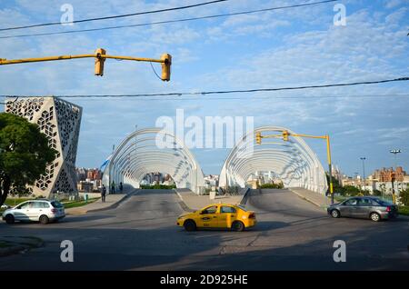 Cordoba, Argentina - January, 2020: Yellow taxi car crossing intersection on green traffic light near Puente del Bicentenario (Bicentenary Bridge) nea Stock Photo