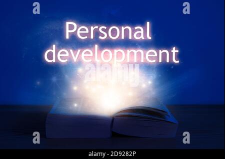 Open book with personal development inscription. Light coming from open book with words personal development. Stock Photo