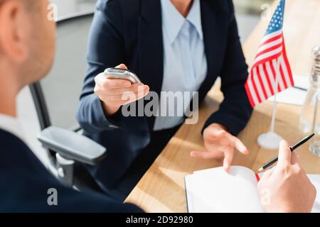 partial view of journalist with dictaphone interviewing politician during press conference on blurred background Stock Photo