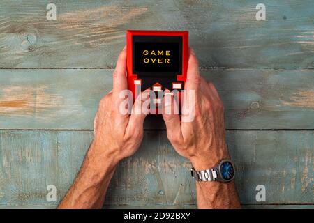 man hands holding retro console playing video games Stock Photo