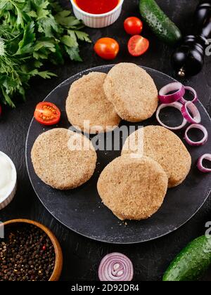 fresh pork cutlets with vegetables on the background Stock Photo