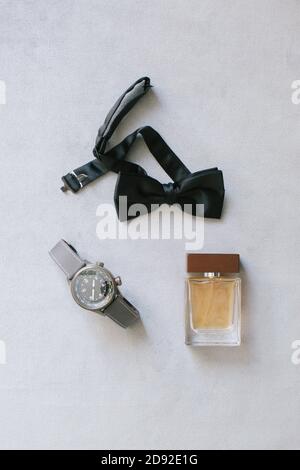 Groom accessories. Wristwatch, bow tie and perfume. Stock Photo