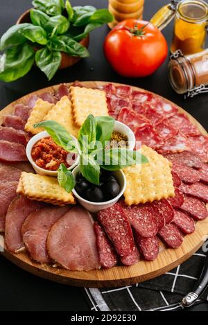 various meats and ham sliced on a wooden plate