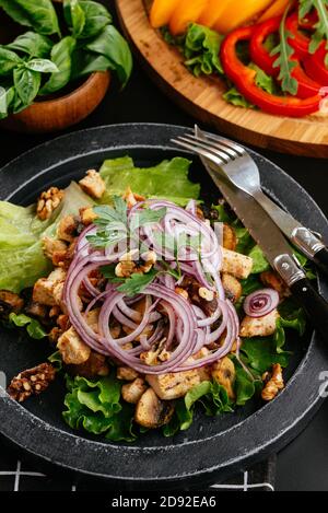 Georgian salad with meat on a black background Stock Photo