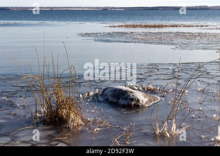 Lake beginning to freeze over in winter, prairie lake, Saskatchewan Canada Stock Photo