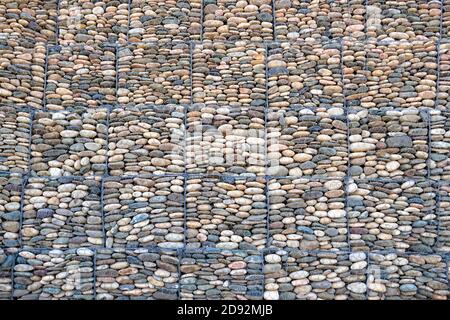 Mesh and stone fence, gabion wall for use in civil engineering, road building, military applications and landscaping. Stock Photo