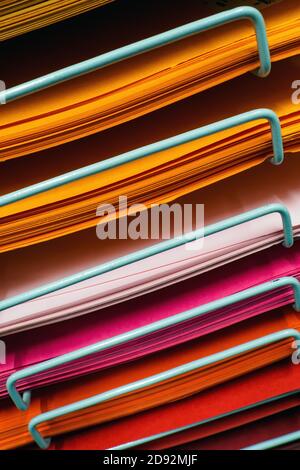 colored paper sheets on a rack, selective focus Stock Photo