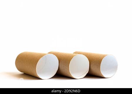 Three cardboard paper tubes in the row on white background. Close-up of empty toilet rolls, copy space Stock Photo