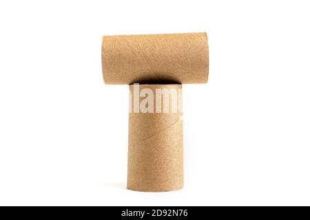 Letter T from composition of two cardboard paper tubes on white background. Close-up of empty toilet rolls Stock Photo