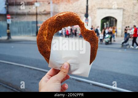 The traditional Turkish bagel called Simit is held by a woman in the hand Stock Photo