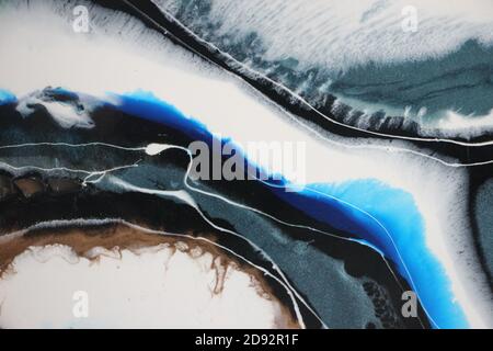 Colorful splash of blue, white, black and silver acrylic ink drops blending and mixing with each other. Luxury fluid art background Stock Photo