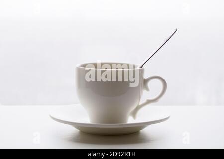 white cup with spoon and saucer on white background Stock Photo