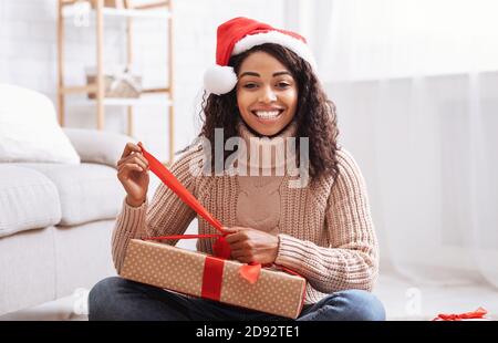 Black Woman Opening Gift Box At Home Stock Photo