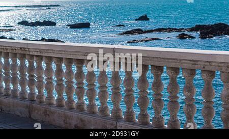 Concrete fence on the waterfront in front of the sea Stock Photo