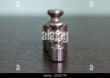 A set of old scratched iron weights for a pharmacy scale. Stock Photo