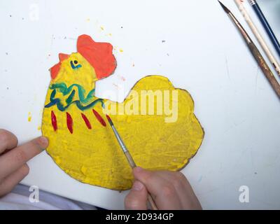Easter chicken from cardboard with your own hands. The concept of children's crafts. We decorate the chicken for Easter with colors. Handmade crafts d Stock Photo
