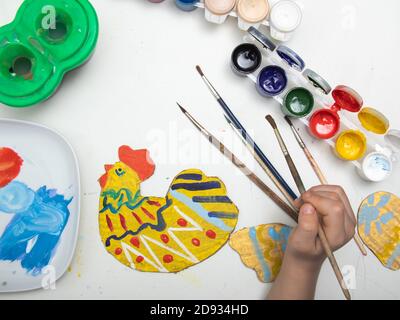 Easter chicken from cardboard with your own hands. The concept of children's crafts. We decorate the chicken for Easter with colors. Handmade crafts d Stock Photo