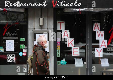 Brussels, Belgium. 2nd Nov, 2020. A man walks past a restaurant that provides only take-away service in Brussels, Belgium, Nov. 2, 2020. Starting from Nov. 2, Belgium moved to stricter lockdown, with rules valid throughout the country to fight against COVID-19. According to the rules, all non-essential businesses have to close. Food stores and supermarkets remain open. Credit: Zheng Huansong/Xinhua/Alamy Live News Stock Photo