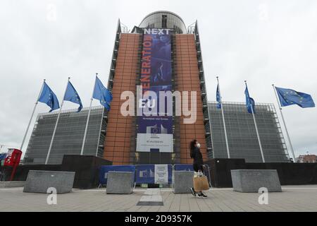 Brussels, Belgium. 2nd Nov, 2020. A woman wearing a face mask walks past the European Commission headquarters in Brussels, Belgium, Nov. 2, 2020. Starting from Nov. 2, Belgium moved to stricter lockdown, with rules valid throughout the country to fight against COVID-19. According to the rules, all non-essential businesses have to close. Food stores and supermarkets remain open. Credit: Zheng Huansong/Xinhua/Alamy Live News Stock Photo