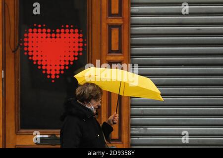 Brussels, Belgium. 2nd Nov, 2020. A woman walks by a closed shop in Brussels, Belgium, Nov. 2, 2020. Starting from Nov. 2, Belgium moved to stricter lockdown, with rules valid throughout the country to fight against COVID-19. According to the rules, all non-essential businesses have to close. Food stores and supermarkets remain open. Credit: Zheng Huansong/Xinhua/Alamy Live News Stock Photo