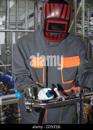 the welder in the workplace. the welder welds the pipe with argon. worker in personal protective equipment. part 2 Stock Photo