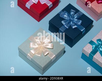 Different colored gift box on pastel blue background. Top view of various present boxes. Birthday, Christmas, wedding, valentine, romantic gifts Stock Photo