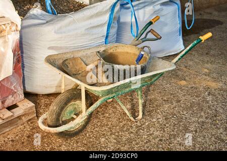 Construction tools. Wheelbarrow, shovel, shovel, sandbags and gravel Stock Photo