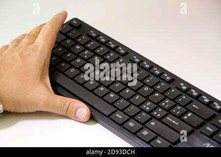 Man works on the pc and types on the keyboard Stock Photo