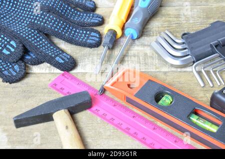 Top view of Working tools,wrench,socket wrench,hammer,screwdriver,plier,electric drill,tape measure,machinist square on wooden board. flat lay design.