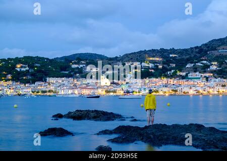 man looking at the small village of Port de la selva at sunset Stock Photo