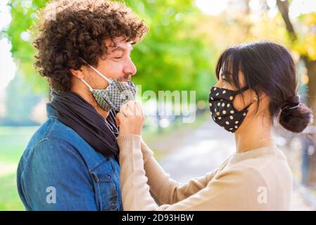 Multiracial couple having tender moments outdoor in a park during autumn after lockdown reopening.curly latino man and woman having fun together