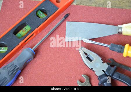 Top view of Working tools,wrench,socket wrench,hammer,screwdriver,plier,electric drill,tape measure,machinist square on wooden board. flat lay design. Stock Photo